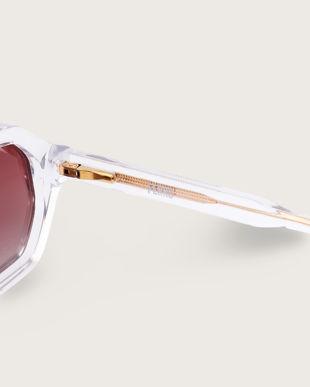 Close-up of FERRO Crystal Ember sunglasses featuring transparent acetate frame and brown gradient lenses.